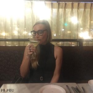 Kelsey drinking her cucumber martini from Anson Eleven