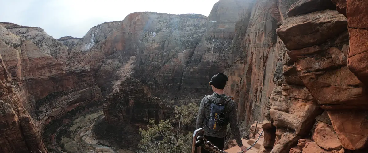 Hiker looking out at Zion Canyon while hiking Angels Landing
