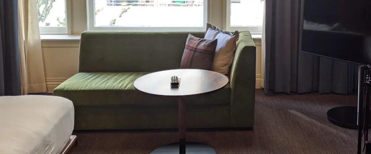 Organized living room with green lounge chair and circle table free of clutter