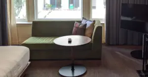 Organized living room with green lounge chair and circle table free of clutter