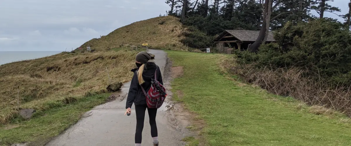 Travelers walking along a path with a red travel bag